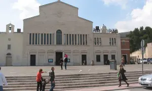 San Giovanni Rotondo: jak zaplanować pielgrzymkę śladami Ojca Pio. Plac przed bazyliką, ludzie wchodzą po schodach.