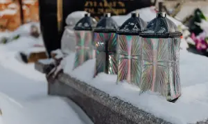 Znicze na grobie w śniegu. Czas zadumy i refleksji, ile trwa pogrzeb, gdy serce krwawi.
