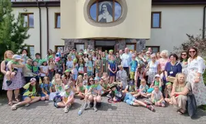 Grupa dzieci i dorosłych przed budynkiem. Czy warto należeć do wspólnoty parafialnej? Różne grupy i ruchy to świetna okazja do integracji.