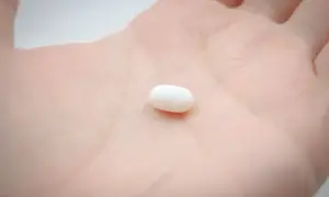 Biała tabletka na dłoni symbolizuje świadome wybory i odpowiedzialność. Kiedy antykoncepcja nie jest grzechem, a narzędziem do planowania rodziny.