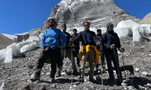 Grupa turystów z kijkami trekkingowymi na tle ośnieżonej góry. Przygotowanie do wędrówki na świętą górę Kailash w Tybecie wymaga odpowiedniego sprzętu.