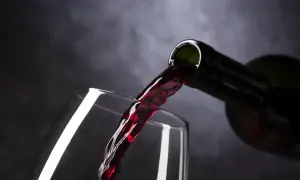 Czerwone wino leje się do kieliszka. Czy picie alkoholu w Adwencie to grzech?