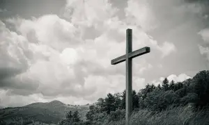 Drewniany krzyż na tle chmur i gór. Czy dbanie o ekologię jest obowiązkiem religijnym chrześcijanina?