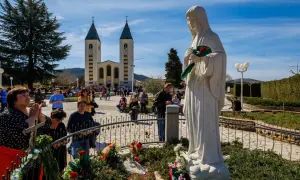Pielgrzymi w Medziugorie modlą się przed figurą Matki Bożej. Przyczyny popularności Medziugorie mimo braku oficjalnego uznania dogmatu.