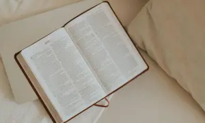Otwarta Biblia na łóżku, symbol poszukiwań i jak znaleźć wspólnotę osób wierzących o podobnej wrażliwości.