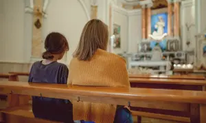 Dwie osoby siedzą w kościele. Zastanawiają się, jakie są obowiązki świadka bierzmowania i kto może nim zostać.