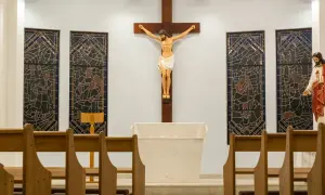 W kościele, przy ołtarzu, wisi krzyż z Jezusem. Obok witraże i ławki. Czy zmazy nocne to grzech?