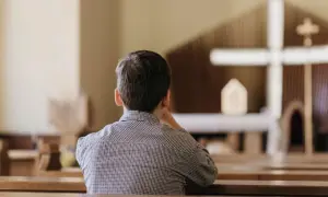 Chłopiec w kościele, zastanawiający się nad przyczynami odejść młodych ludzi z kościoła i dylematami pokoleniowymi.
