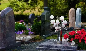 Nagrobek z kwiatami. Rozważania o skutkach prawnych pochowania dwóch osób w jednym grobie głębinowym.