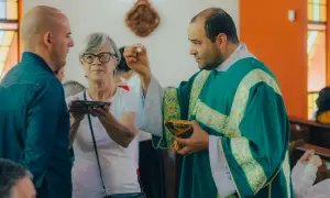 Kapłan udziela komunii. W historii Kościoła, przyczyny powstania nowych dogmatów często wiązały się z potrzebą wyjaśnienia wiary w obliczu nowych wyzwań.