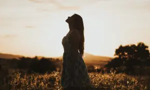 Kobieta w letniej sukience wpatruje się w niebo, szukając odpowiedzi. Jak odróżnić natchnienie boże od własnych projekcji psychicznych?