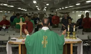 Nabożeństwo na okręcie. Różnica między dogmatem a osobistym przekonaniem w wierze jest widoczna w postawach wiernych.