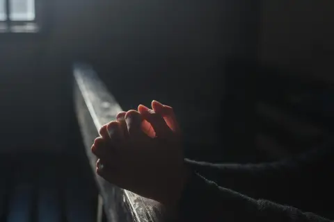 Dłonie złożone do modlitwy w półmroku. Czy używanie wibratora jest grzechem? Pytanie w ciszy.