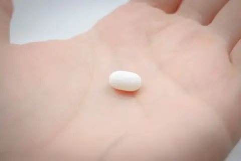 Biała tabletka na dłoni symbolizuje świadome wybory i odpowiedzialność. Kiedy antykoncepcja nie jest grzechem, a narzędziem do planowania rodziny.