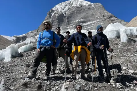 Grupa turystów z kijkami trekkingowymi na tle ośnieżonej góry. Przygotowanie do wędrówki na świętą górę Kailash w Tybecie wymaga odpowiedniego sprzętu.