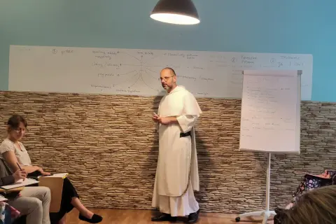 Wykład o tym, jak rozmawiać z niewierzącymi rodzicami o chęci powrotu do kościoła. Na tablicy schemat relacji i trudności.