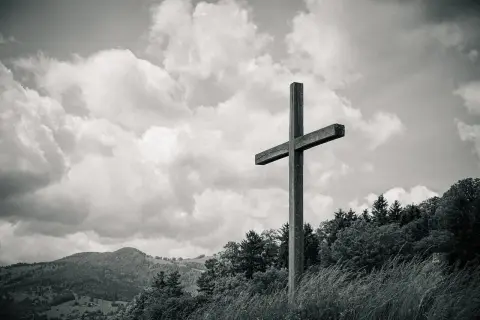 Drewniany krzyż na tle burzowych chmur. Symbolizuje drogę do zrozumienia, jak odróżnić natchnienie boże od własnych pragnień i emocji.
