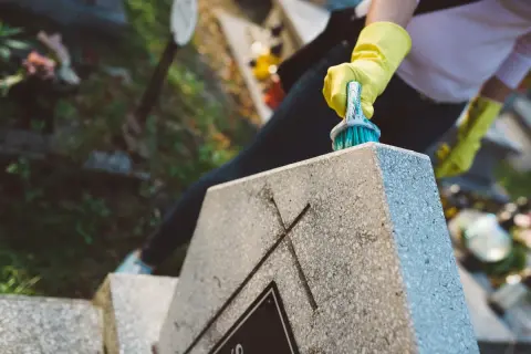 Rękawiczki ochronne i szczotka do czyszczenia nagrobka. Zapobiegaj objawom korozji na elementach metalowych, by nagrobek służył latami.
