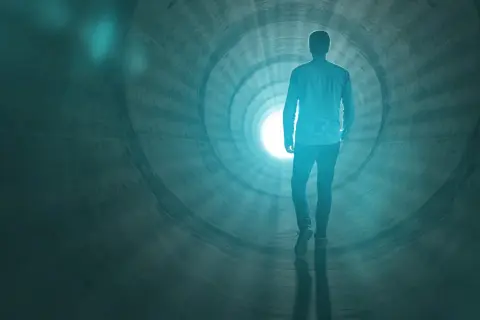 Człowiek idzie w stronę światła w tunelu, symbolizującym to, co się dzieje po śmierci.