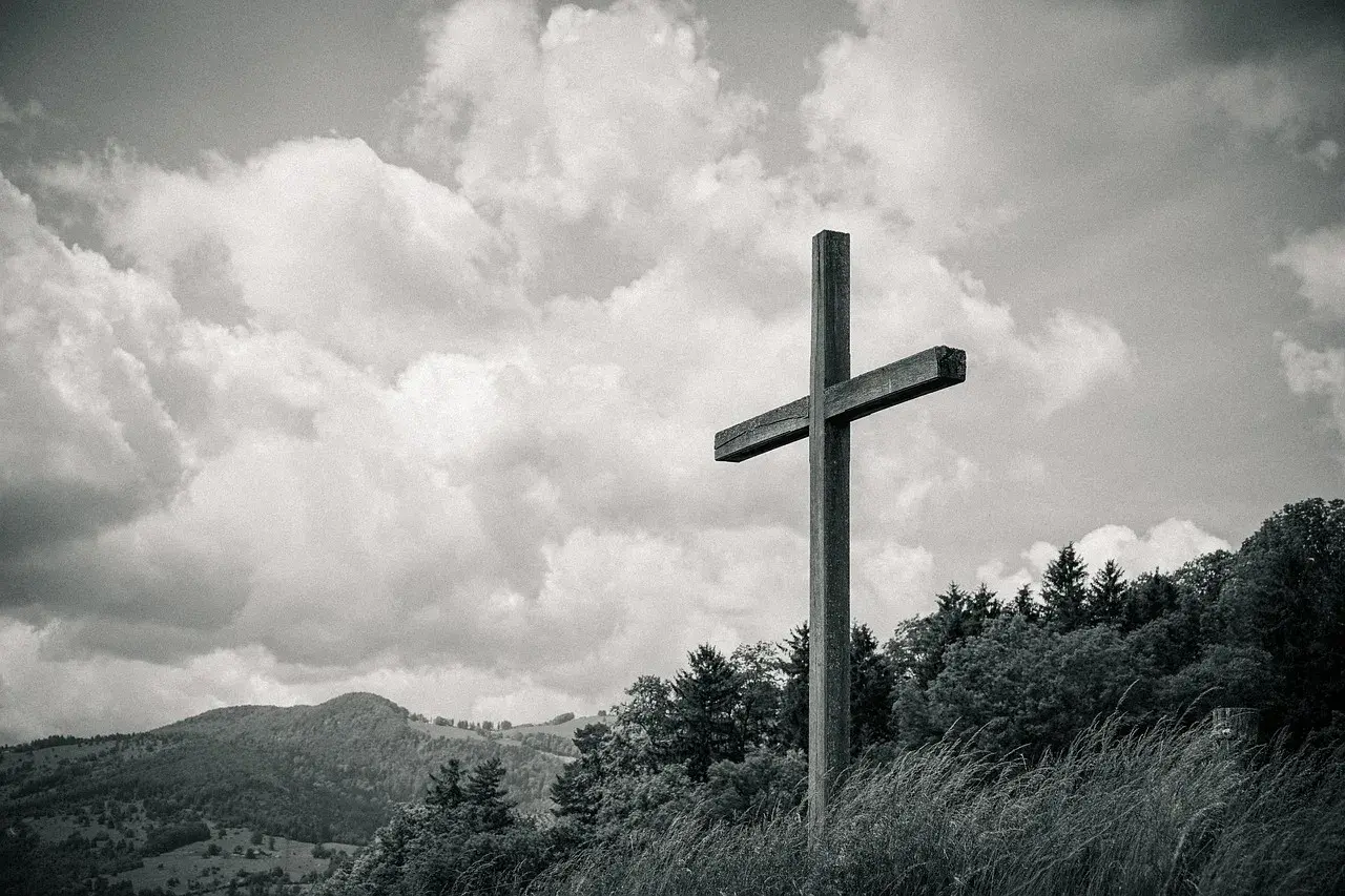 Drewniany krzyż na tle chmur i gór. Czy dbanie o ekologię jest obowiązkiem religijnym chrześcijanina?