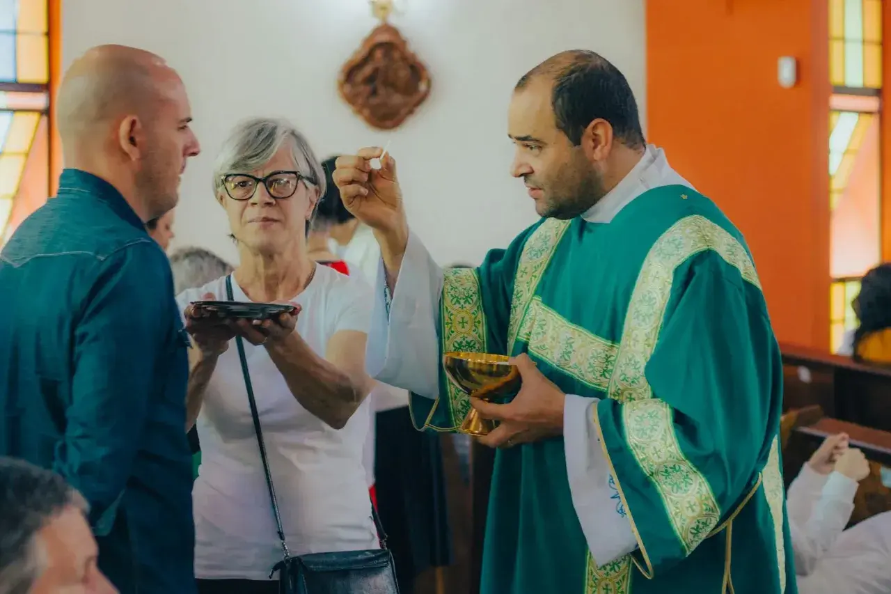 Kapłan udziela komunii. W historii Kościoła, przyczyny powstania nowych dogmatów często wiązały się z potrzebą wyjaśnienia wiary w obliczu nowych wyzwań.