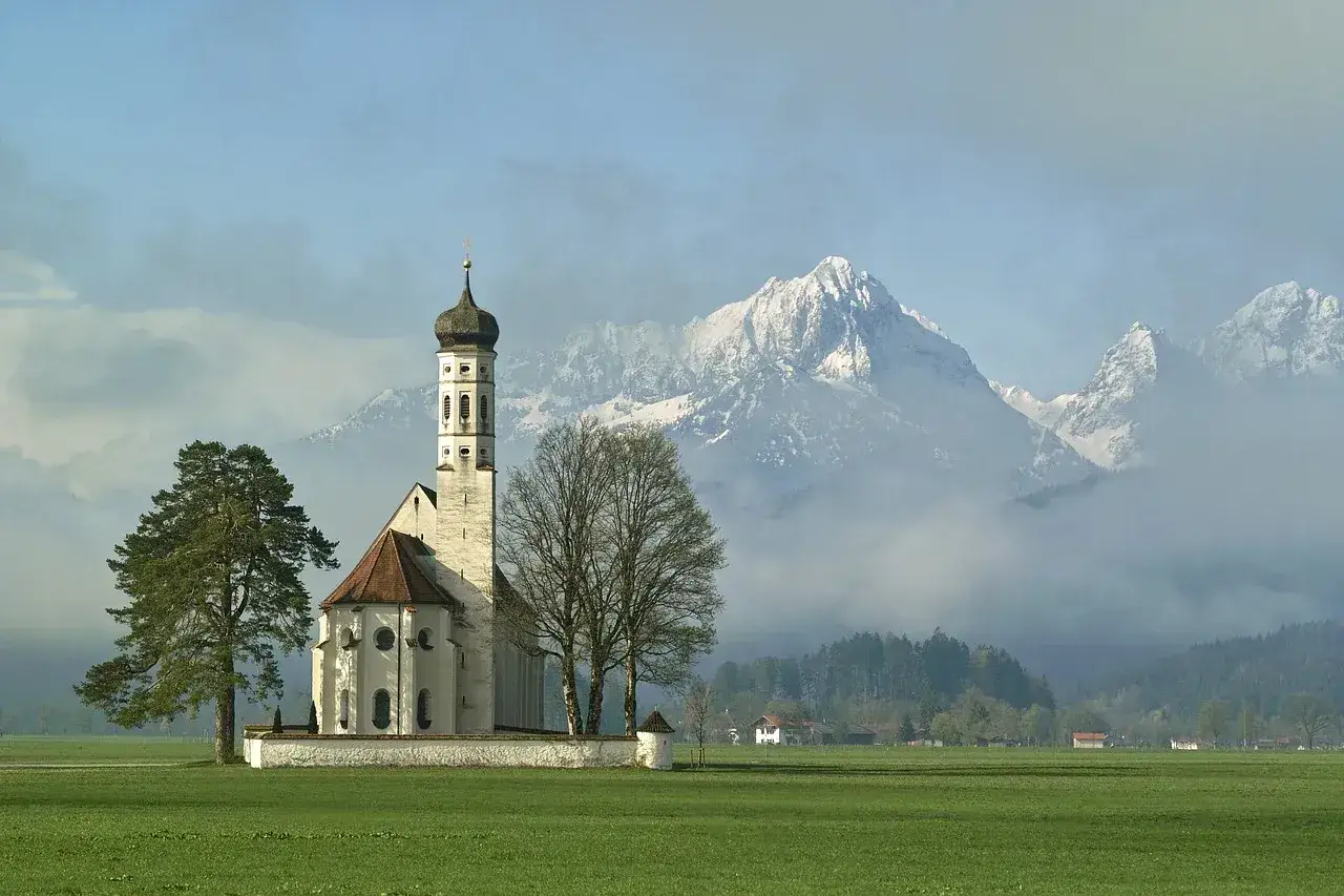 Kościół na tle gór. Czy można być dobrym człowiekiem nie wierząc w boga? Piękno natury i architektury skłania do refleksji.