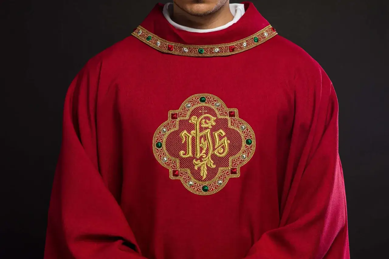 Czerwona szata liturgiczna z symbolem IHS. Kolory szat księdza mają znaczenie symboliczne, odzwierciedlając czas liturgiczny.