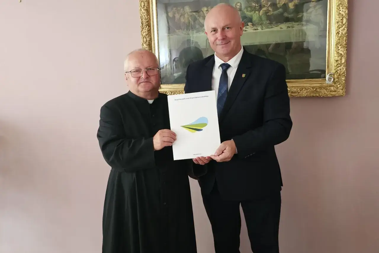 Ksiądz i urzędnik omawiają, jak sfinansować remont zabytkowego kościoła dotacje i zbiórki.
