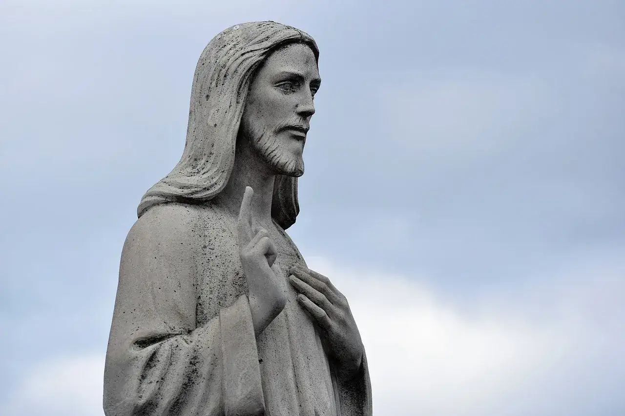 Kamienna rzeźba Jezusa z podniesionym palcem, symbolizująca nauczanie i przyczyny powstania nowych dogmatów w historii Kościoła.