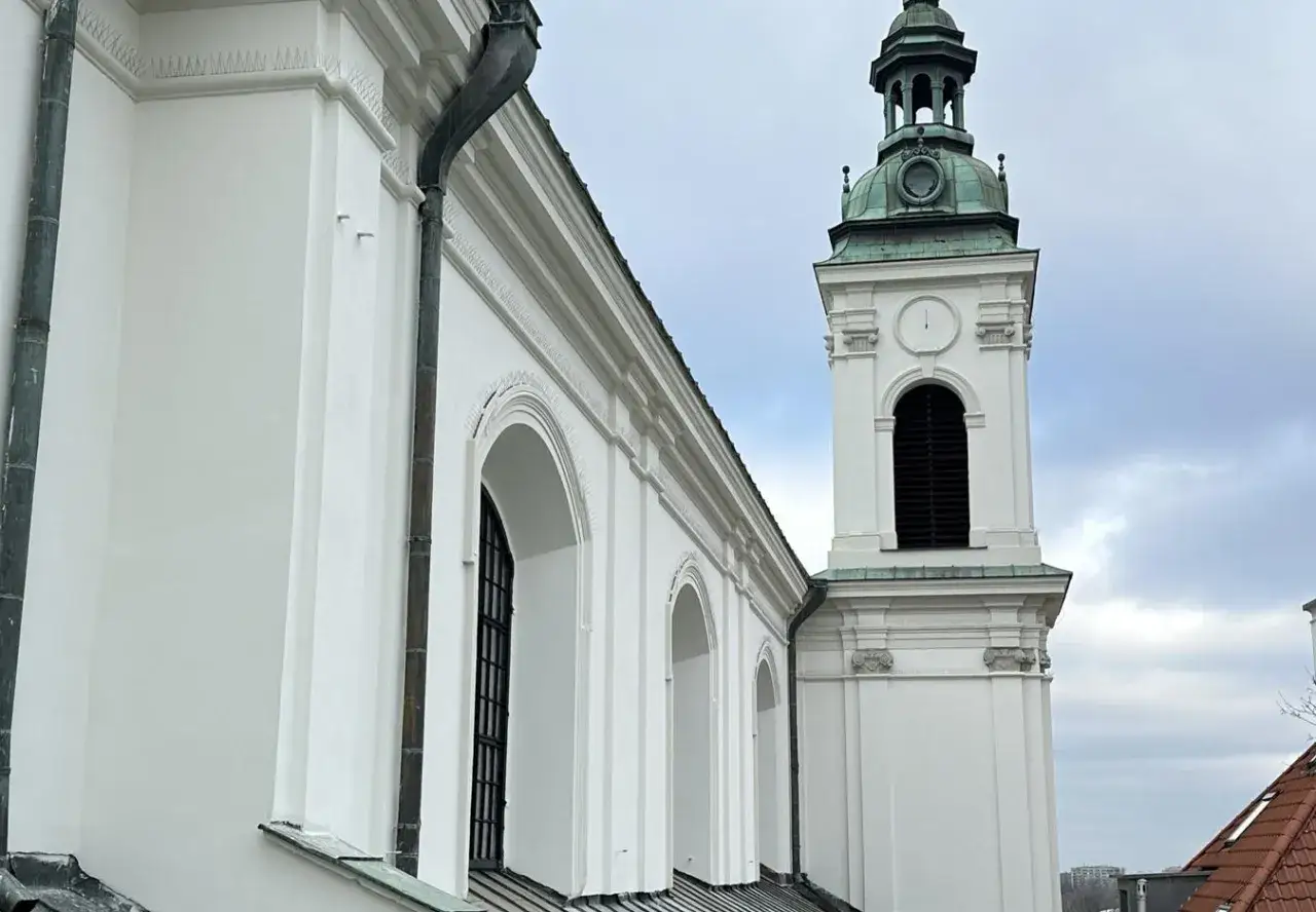 Biały zabytkowy kościół z zieloną wieżą. Jak sfinansować remont zabytkowego kościoła dotacje i zbiórki?