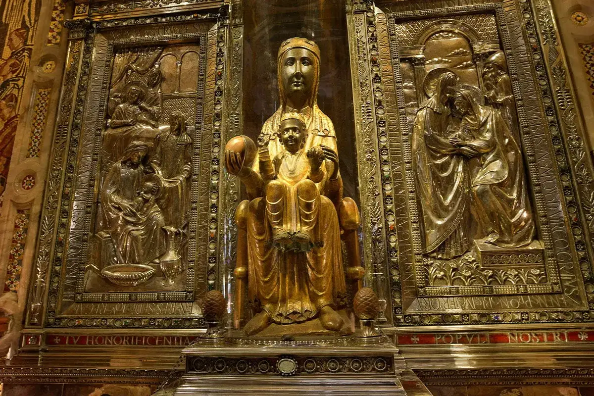 Złota figura Madonny z Dzieciątkiem w centrum, otoczona reliefami. Symbolika tych dzieł może wyjaśniać przyczyny czci czarnych madonn w europejskich sanktuariach.