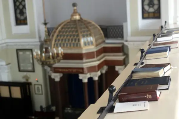 Wnętrze synagogi z księgami na balustradzie. Poznaj zasady ubioru i etykiety, jak zachować się w meczecie i synagodze.