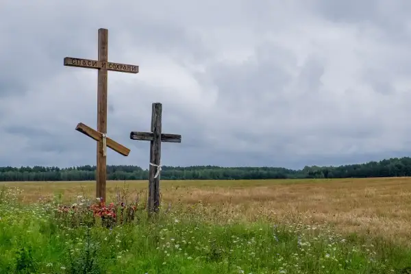 Trzy krzyże na tle pola i lasu. Jeden z nich ma napis "Spasi i Sochrani". Czy horoskopy to grzech?