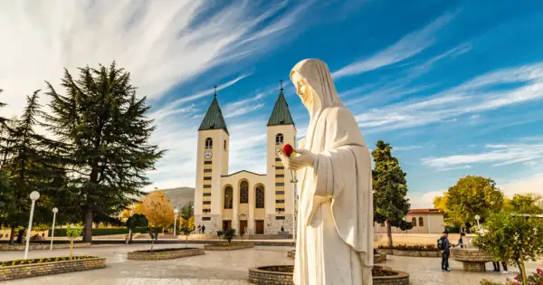 Pomnik Matki Bożej z różą przed kościołem. To miejsce objawień, nie tylko święte miasto.