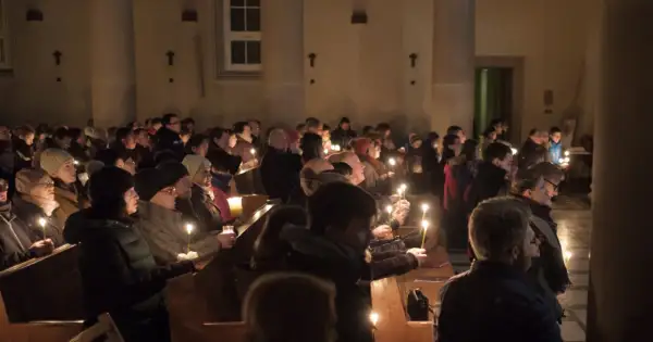 Ludzie z zapalonymi świecami w kościele podczas Rorat. Trwają one przez 24 dni Adwentu.