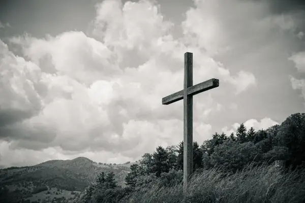 Drewniany krzyż na tle chmur i gór. Czy dbanie o ekologię jest obowiązkiem religijnym chrześcijanina?