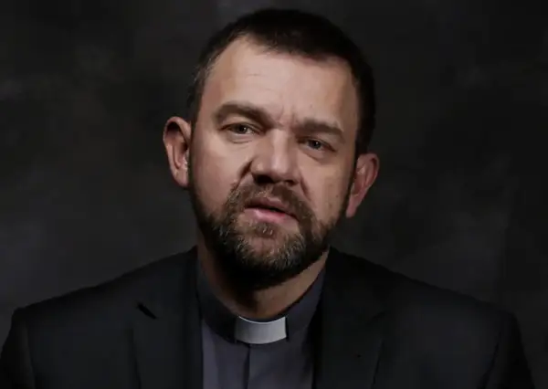 Duchowny z brodą w czarnym garniturze i białej kolarii. Jego spojrzenie sugeruje dylemat posłuszeństwa sumieniu a nauczanie hierarchów kościelnych.