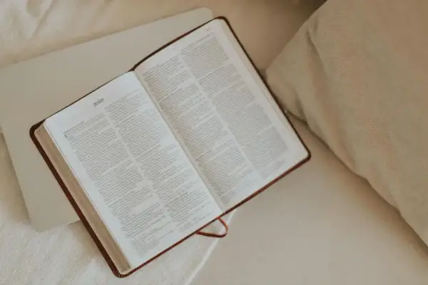 Otwarta Biblia na łóżku, symbol poszukiwań i jak znaleźć wspólnotę osób wierzących o podobnej wrażliwości.