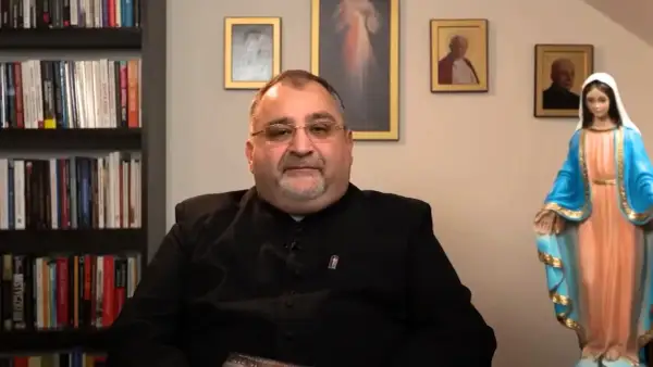 Ksiądz tłumaczy, jak przygotować się do spowiedzi generalnej rachunek sumienia. W tle obrazy religijne i figura Matki Bożej.