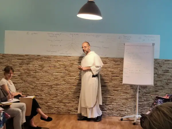 Wykład o tym, jak rozmawiać z niewierzącymi rodzicami o chęci powrotu do kościoła. Na tablicy schemat relacji i trudności.