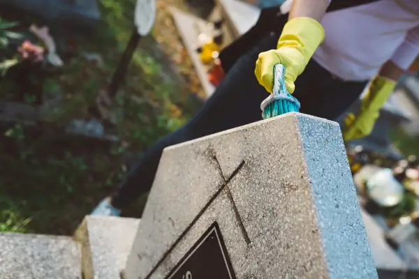 Rękawiczki ochronne i szczotka do czyszczenia nagrobka. Zapobiegaj objawom korozji na elementach metalowych, by nagrobek służył latami.