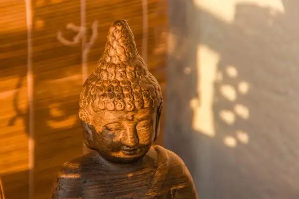 Posąg Buddy w cieniu, symbolizujący pozytywne skutki modlitwy dla zdrowia psychicznego i fizycznego, potwierdzone dowodami naukowymi.