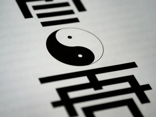 Symbol Yin Yang na białym tle, otoczony chińskimi znakami. Ilustruje różnicę między wiarą a wiedzą, perspektywę filozoficzną i teologiczną.